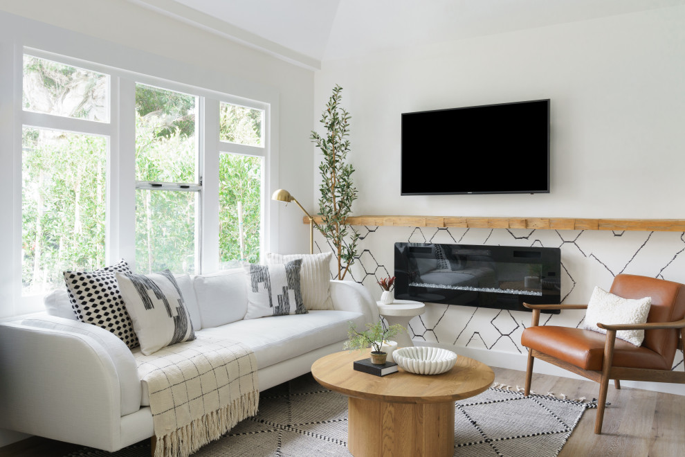 Immagine di un piccolo soggiorno boho chic aperto con pareti bianche, pavimento in laminato, camino sospeso, TV a parete, pavimento marrone e soffitto a volta