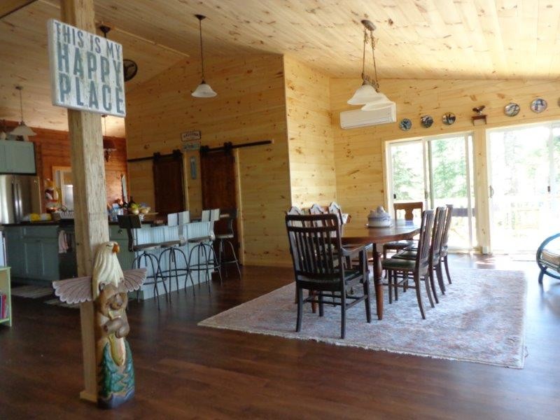 Inspiration for a mid-sized rustic medium tone wood floor and brown floor kitchen/dining room combo remodel with beige walls and no fireplace