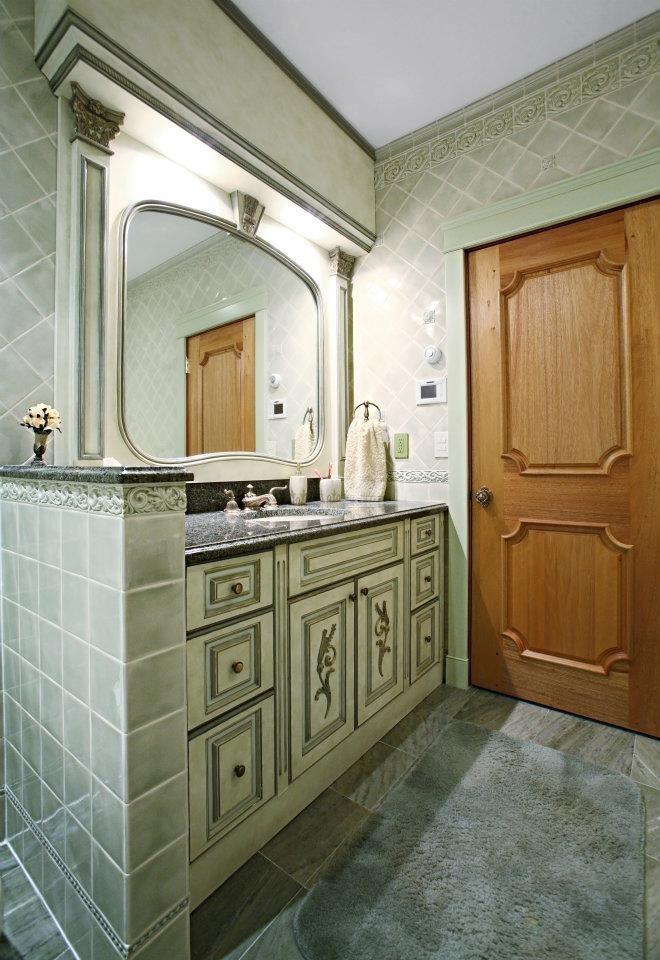 Inspiration for a mid-sized mediterranean 3/4 bathroom in New York with an integrated sink, glass-front cabinets, green cabinets, granite benchtops, an alcove tub, a shower/bathtub combo, a one-piece toilet, white tile, ceramic tile, white walls and marble floors.