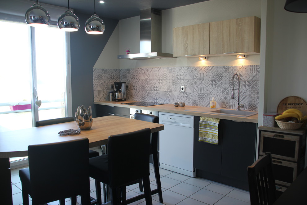 Inspiration for a mid-sized contemporary galley eat-in kitchen in Toulouse with an integrated sink, beaded inset cabinets, black cabinets, laminate benchtops, grey splashback, cement tile splashback, stainless steel appliances, ceramic floors, with island and grey floor.