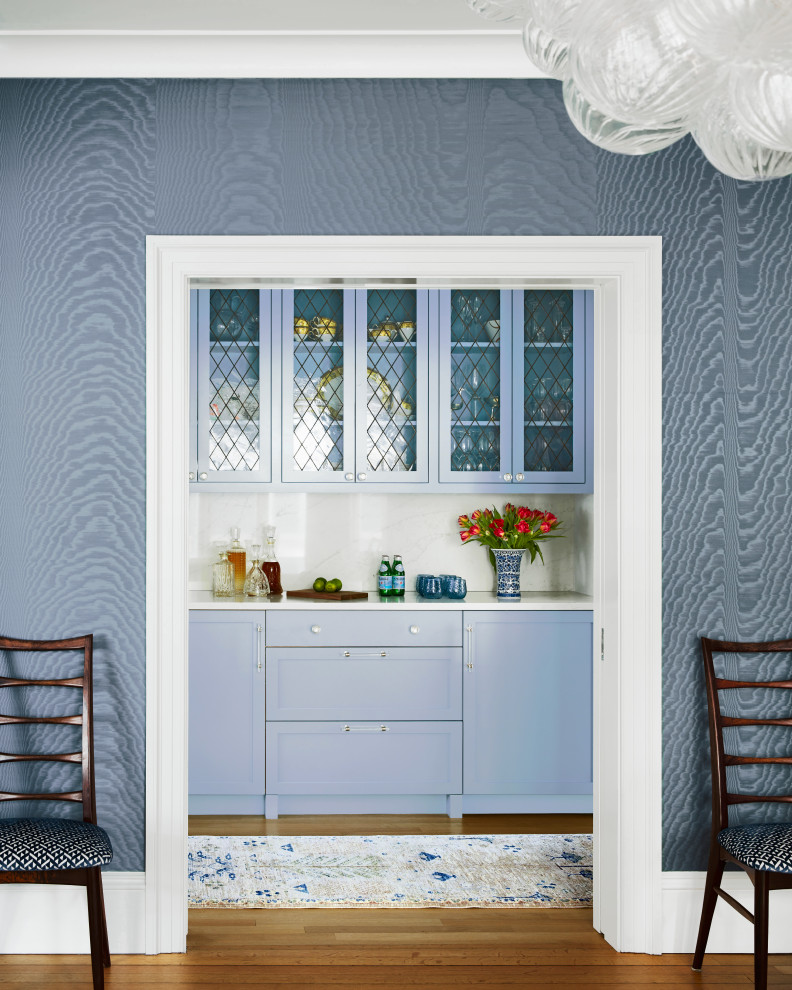 Inspiration for a transitional single-wall home bar remodel in Boston with shaker cabinets, blue cabinets and white countertops