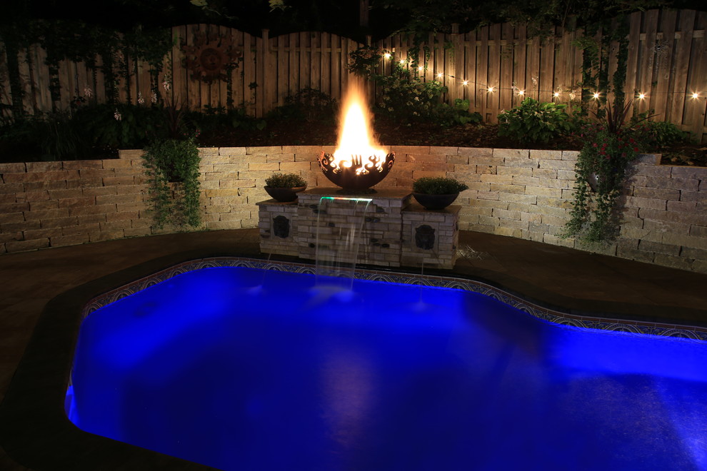 This is an example of a mid-sized eclectic backyard garden in Omaha with a fire feature and concrete pavers.