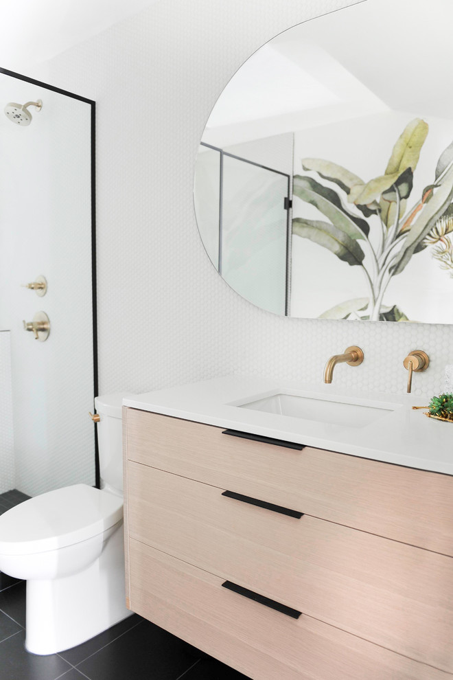 Mid-sized eclectic 3/4 bathroom in Other with flat-panel cabinets, light wood cabinets, white walls, an undermount sink, black floor, white benchtops, a two-piece toilet, white tile, mosaic tile, an alcove shower, porcelain floors, quartzite benchtops and a hinged shower door.