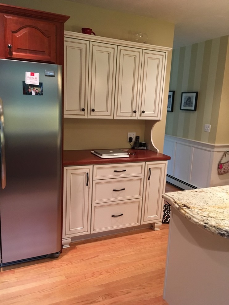 Eat-in kitchen - transitional u-shaped light wood floor eat-in kitchen idea in Boston with an undermount sink, raised-panel cabinets, granite countertops, subway tile backsplash, stainless steel appliances and an island