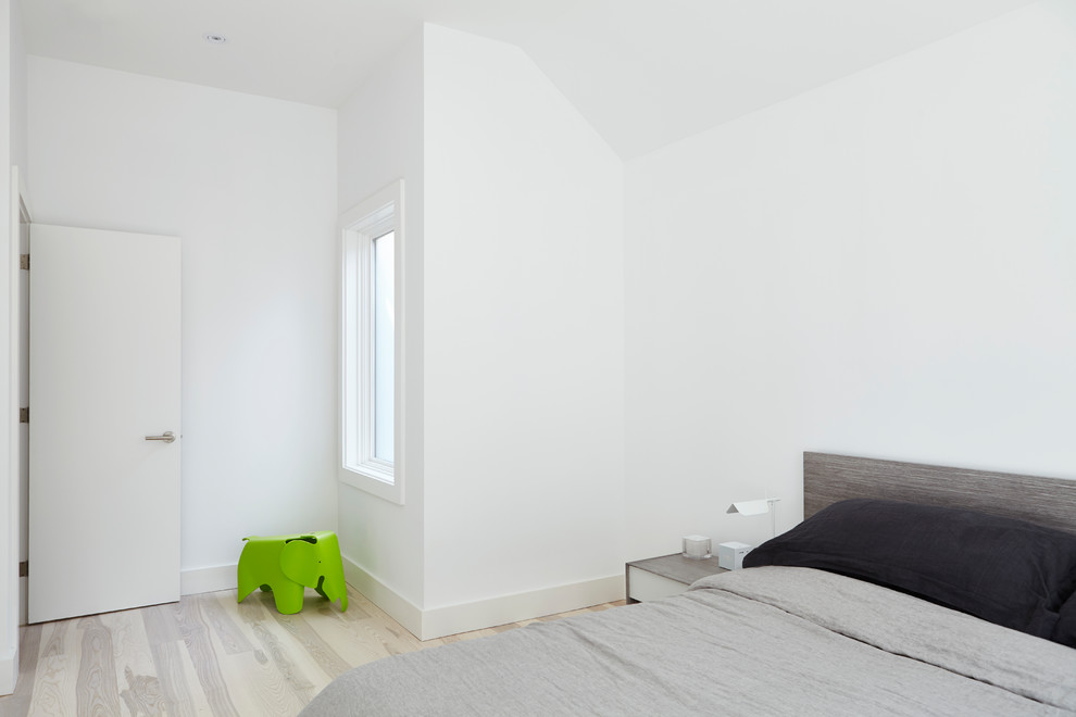 Photo of a small modern master bedroom in Toronto with white walls, light hardwood floors and multi-coloured floor.