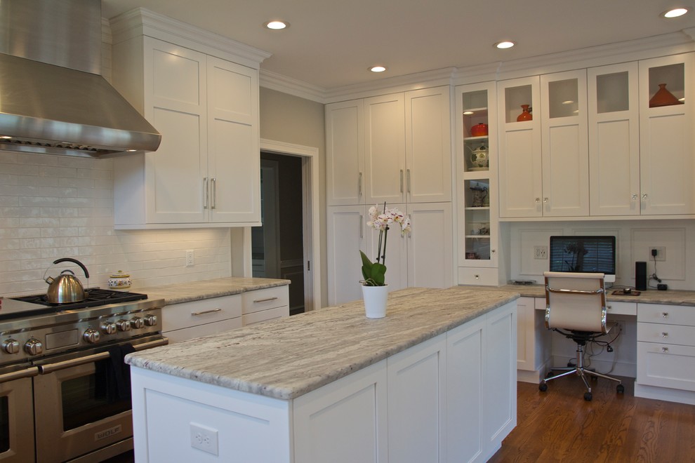 Eat-in kitchen - large transitional l-shaped medium tone wood floor and brown floor eat-in kitchen idea in Cincinnati with an undermount sink, shaker cabinets, white cabinets, granite countertops, white backsplash, ceramic backsplash, paneled appliances and an island