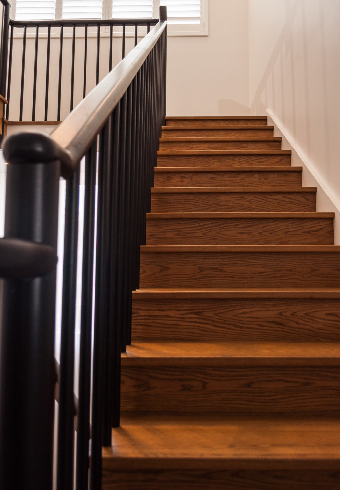 Cette image montre un grand escalier courbe design avec des marches en bois, des contremarches en bois et un garde-corps en bois.