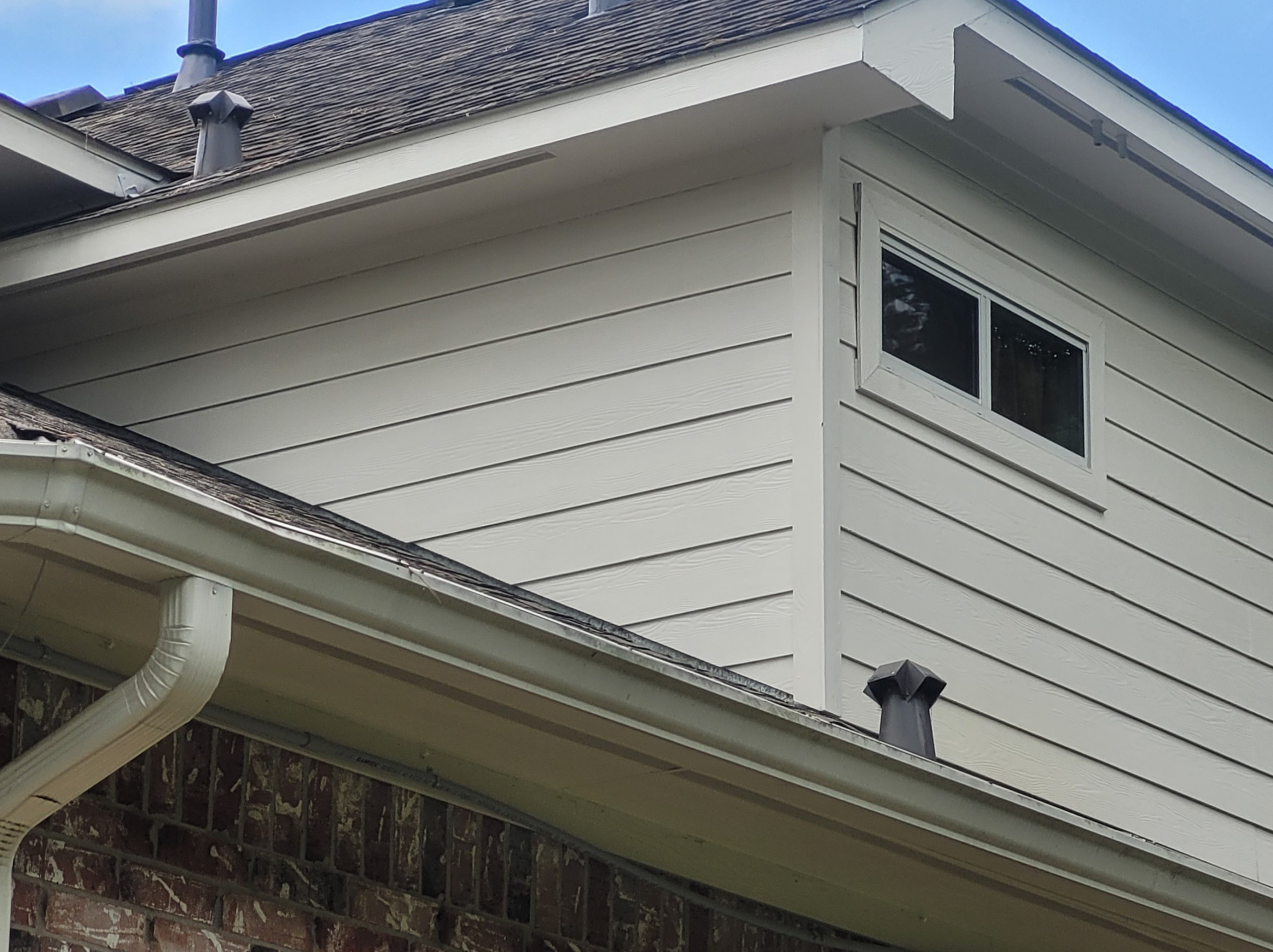 Fiber cement siding repaired with proper 1-2" gap at roof