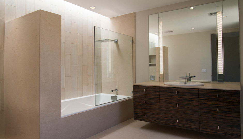 Photo of a large contemporary master bathroom in Phoenix with flat-panel cabinets, dark wood cabinets, an alcove tub, a shower/bathtub combo, a two-piece toilet, beige tile, porcelain tile, beige walls, limestone floors, a drop-in sink, limestone benchtops, beige floor and an open shower.