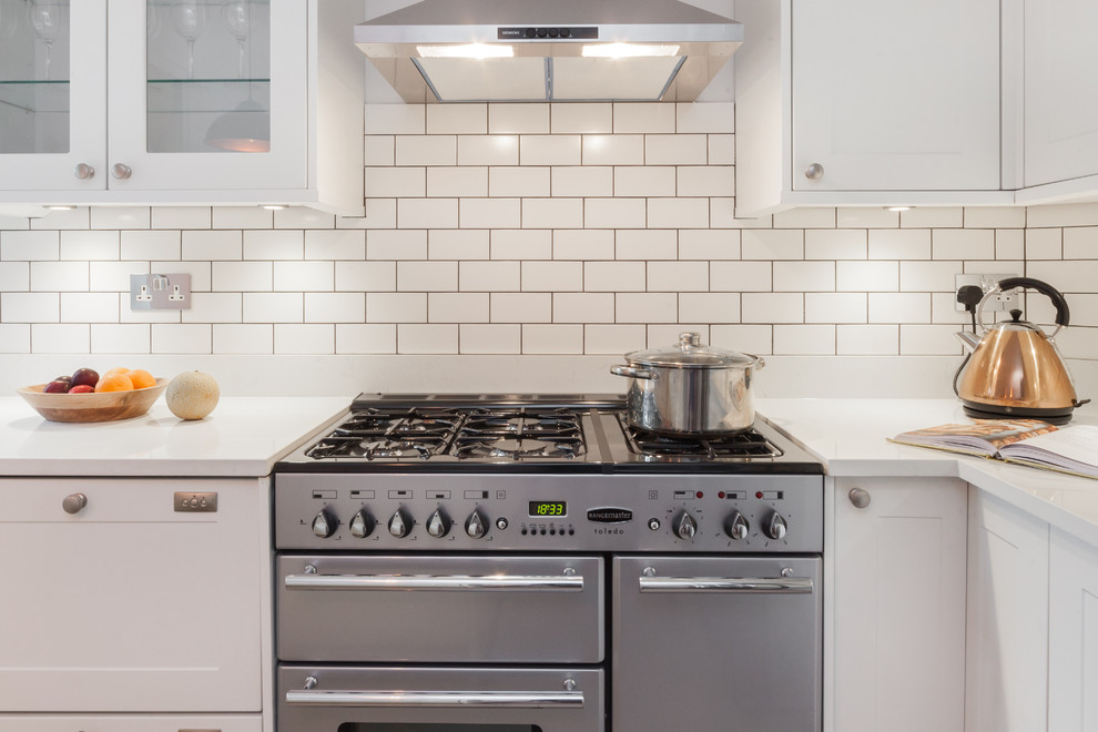 Photo of a mid-sized eclectic u-shaped eat-in kitchen in London with an undermount sink, shaker cabinets, white cabinets, quartzite benchtops, white splashback, subway tile splashback, stainless steel appliances, porcelain floors, a peninsula and grey floor.