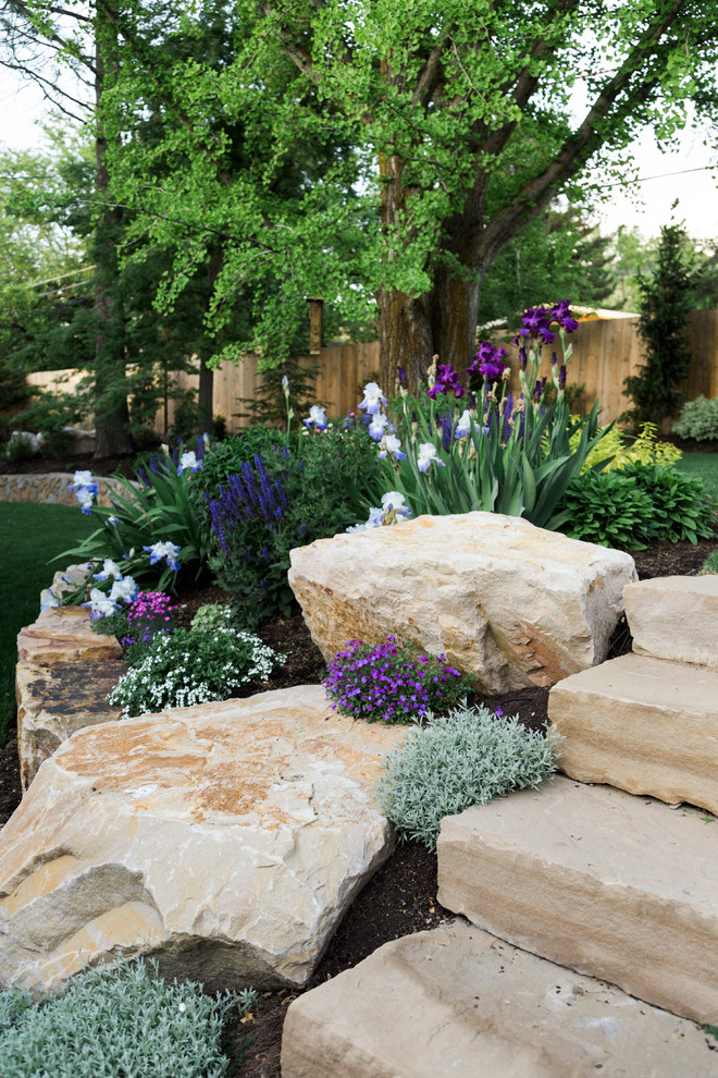 Photo of a traditional garden in Salt Lake City with with flowerbed, natural stone pavers and a wood fence.