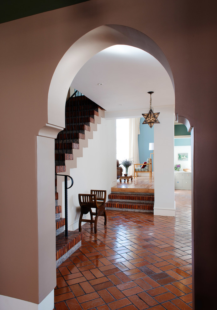 Design ideas for a large eclectic foyer in Los Angeles with multi-coloured walls, brick floors and a double front door.