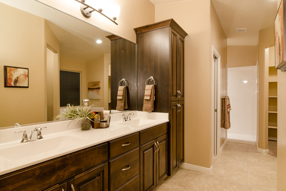 This is an example of a large traditional master bathroom in Salt Lake City with raised-panel cabinets, dark wood cabinets, an alcove tub, an open shower, beige walls, ceramic floors, an integrated sink and solid surface benchtops.