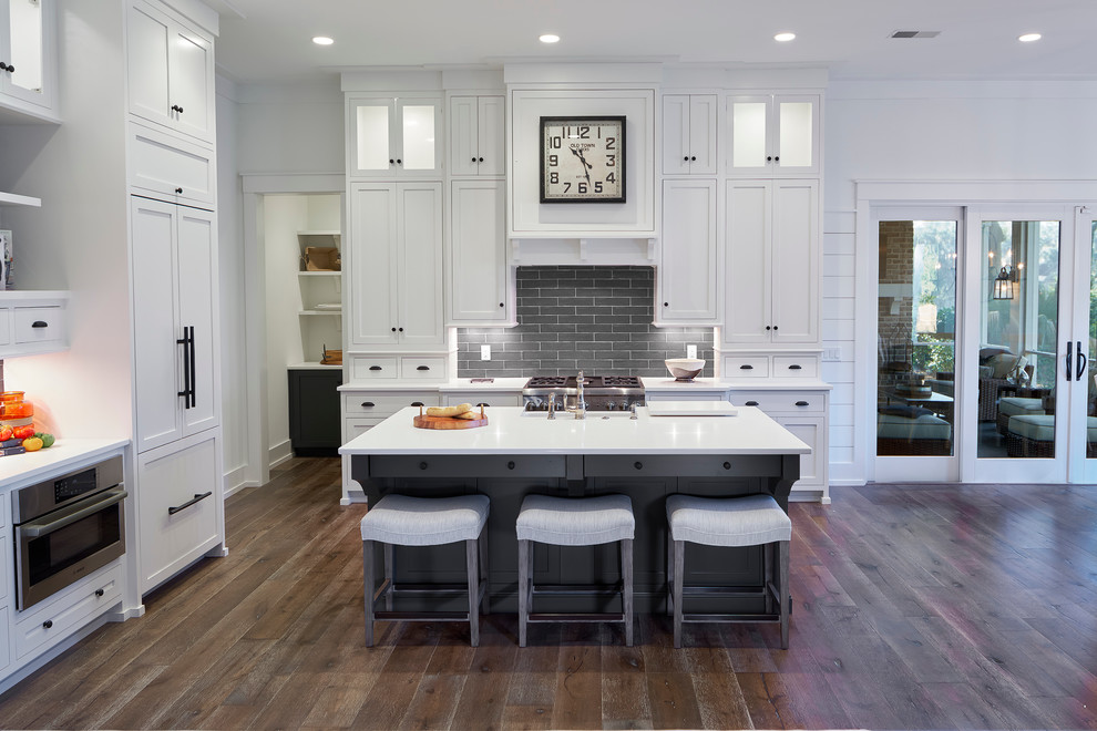 Kitchen - transitional dark wood floor kitchen idea in Atlanta with shaker cabinets, white cabinets, gray backsplash, subway tile backsplash, paneled appliances and an island