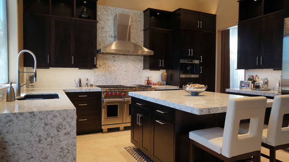 Kitchen - transitional l-shaped porcelain tile and beige floor kitchen idea in Phoenix with an undermount sink, recessed-panel cabinets, dark wood cabinets, quartz countertops, white backsplash, ceramic backsplash, stainless steel appliances and an island
