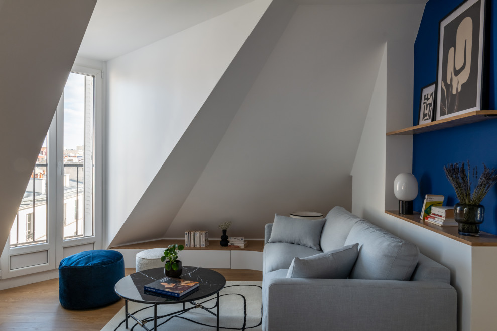 Salon mansardé ou avec mezzanine?[Inspiration pour salon mansardé ou avec mezzanine With un mur bleu, un sol en bois brun, un téléviseur indépendant, un sol marron and éclairage.]:[Inspiration pour salons mansardés ou avec mezzanine With un mur bleu, un sol en bois brun, un téléviseur indépendant, un sol marron and éclairage.]