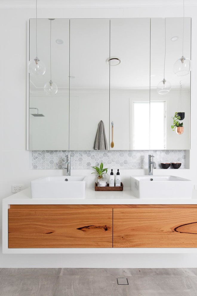 Photo of a contemporary bathroom in Sydney with flat-panel cabinets, medium wood cabinets, gray tile, mosaic tile, white walls, concrete floors, a vessel sink, grey floor and white benchtops.