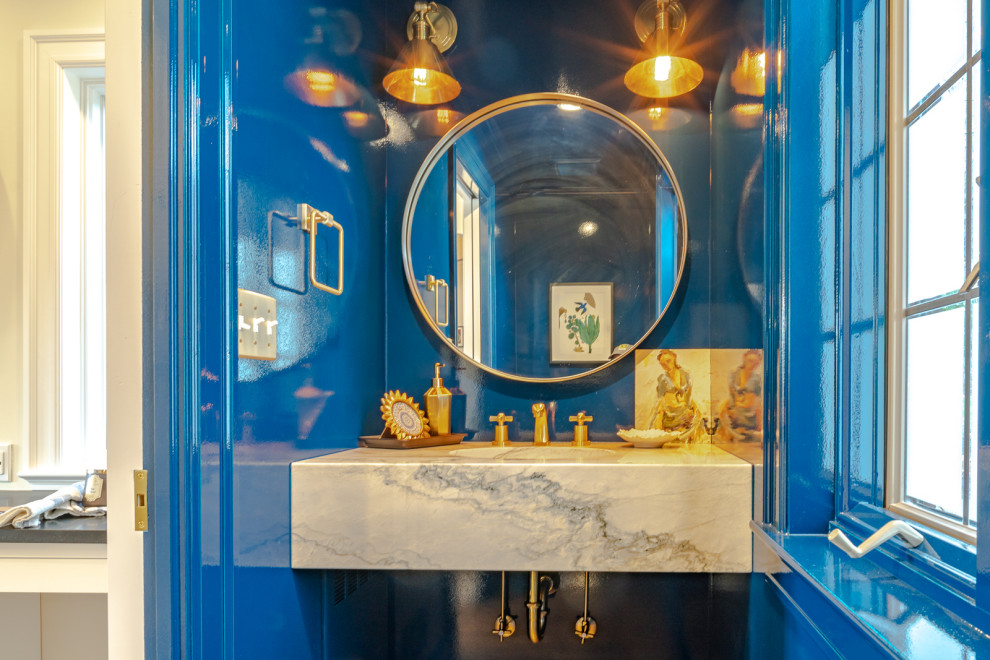 Inspiration for a small traditional powder room in Other with open cabinets, white cabinets, a two-piece toilet, blue walls, medium hardwood floors, an undermount sink, marble benchtops, brown floor and white benchtops.