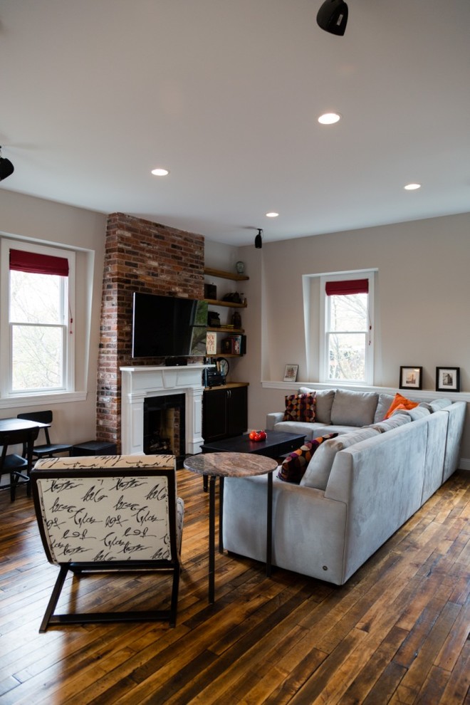 This is an example of a mid-sized traditional loft-style living room in St Louis with white walls, medium hardwood floors, a wall-mounted tv and a home bar.