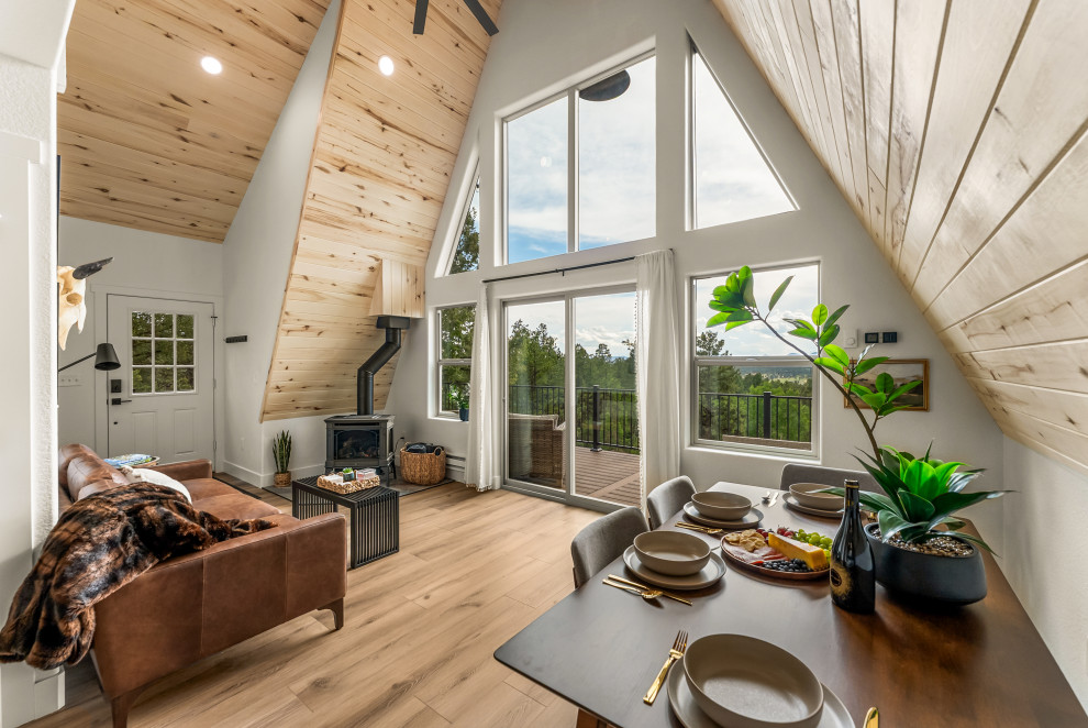 Breakfast nook - small rustic laminate floor, brown floor, wood ceiling and wood wall breakfast nook idea with white walls and a wood stove