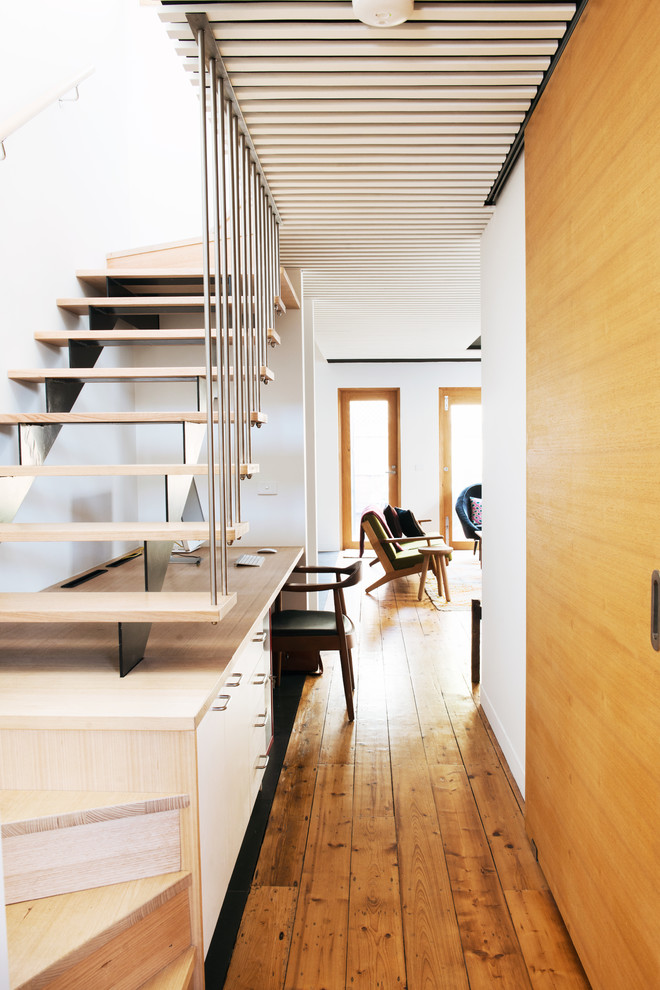 Photo of a large scandinavian hallway in Melbourne with white walls and light hardwood floors.