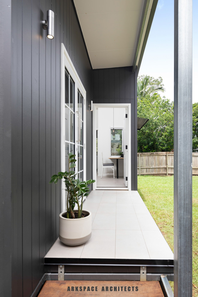 Photo of a contemporary front door in Brisbane with grey walls, porcelain floors, a single front door, a gray front door and grey floor.