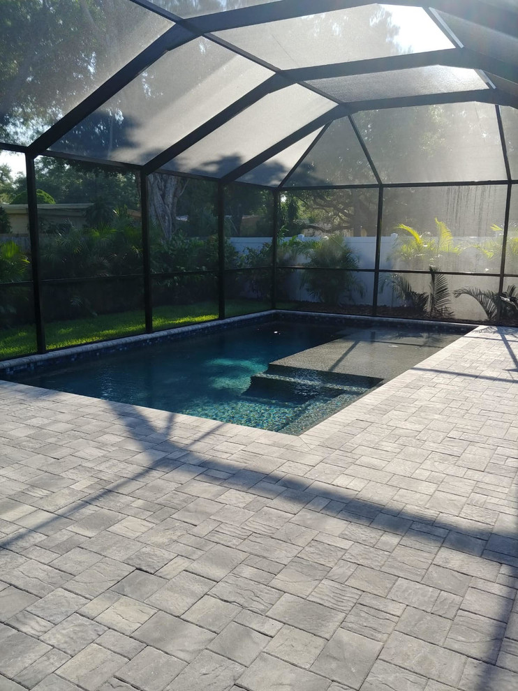 Design ideas for a mid-sized modern backyard custom-shaped pool in Tampa with brick pavers.