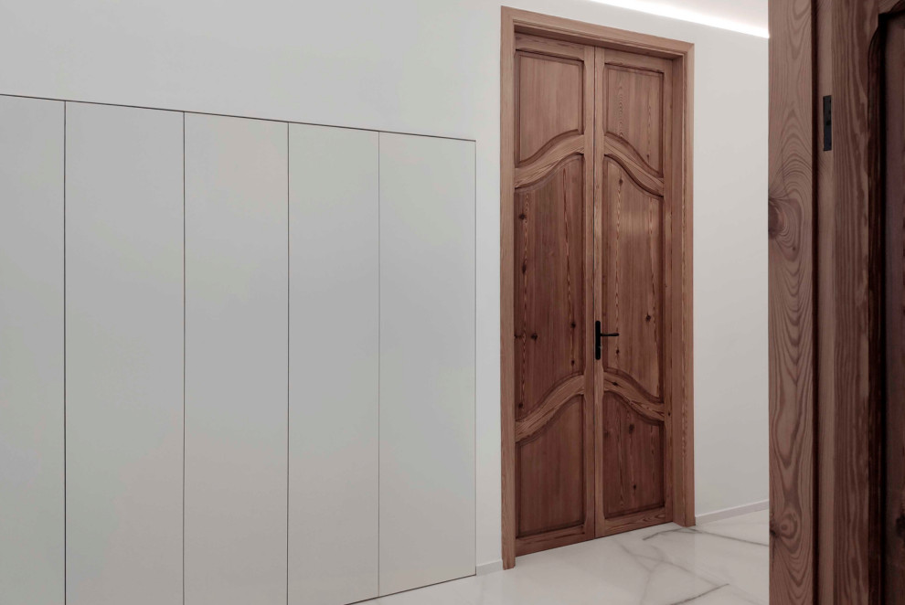 Foto di un grande ingresso o corridoio minimalista con pareti bianche, pavimento in gres porcellanato, pavimento bianco e travi a vista