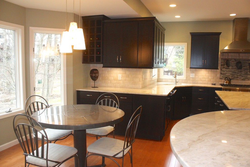 Example of a mid-sized minimalist u-shaped medium tone wood floor eat-in kitchen design with shaker cabinets, dark wood cabinets, beige backsplash, stainless steel appliances, an island and subway tile backsplash
