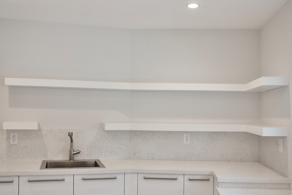 This is an example of a large modern galley utility room in Miami with an utility sink, flat-panel cabinets, white cabinets, quartz benchtops, white walls, marble floors and a side-by-side washer and dryer.