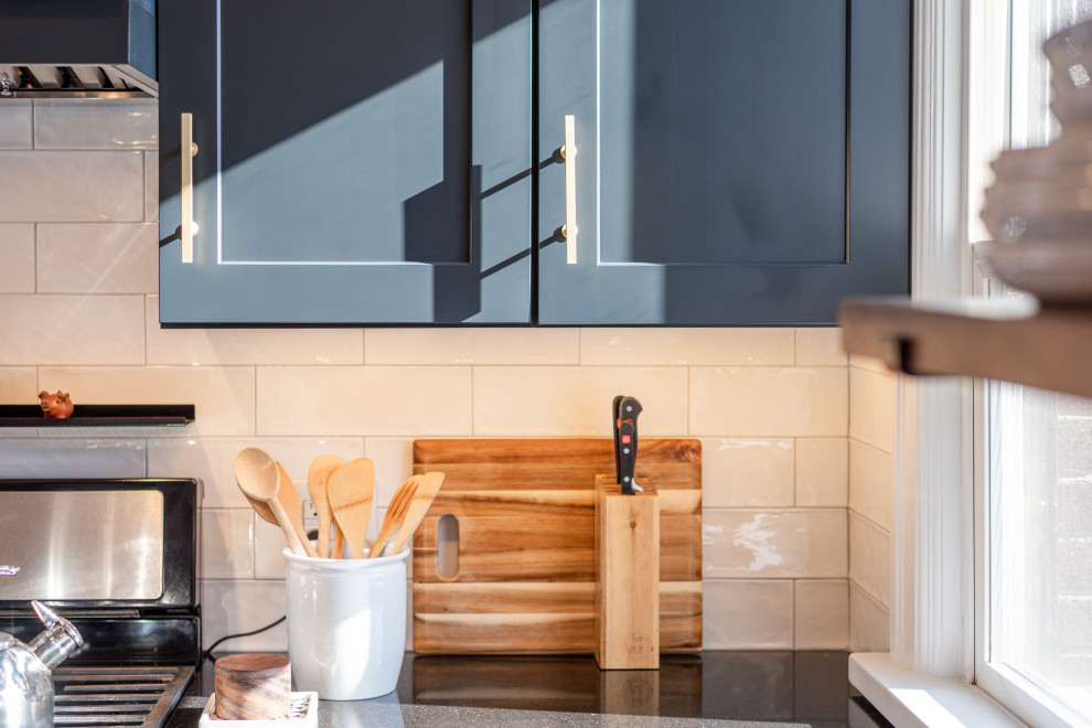 Idéer för att renovera ett avskilt, litet funkis svart svart parallellkök, med en undermonterad diskho, skåp i shakerstil, svarta skåp, bänkskiva i kvartsit, vitt stänkskydd, stänkskydd i keramik, rostfria vitvaror, mörkt trägolv, en halv köksö och brunt golv