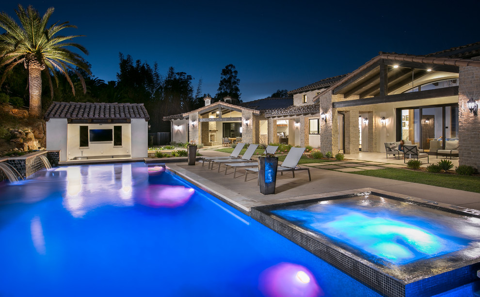 This is an example of a mediterranean backyard rectangular pool in San Diego with a hot tub.