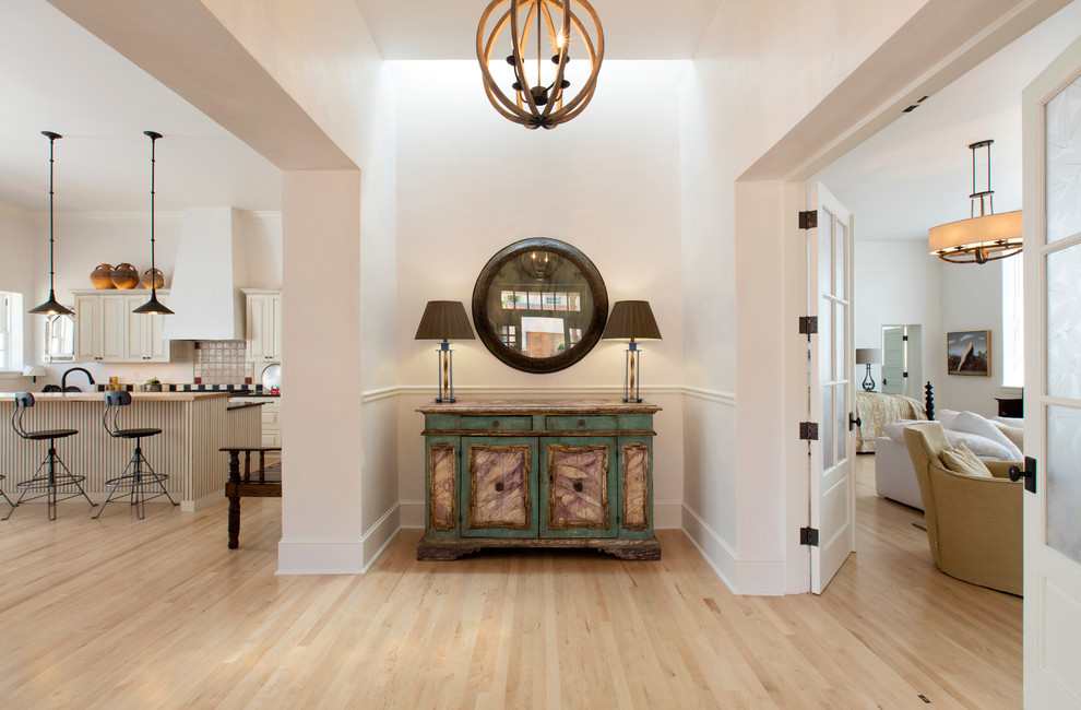 Design ideas for a mid-sized traditional hallway in Albuquerque with white walls and light hardwood floors.