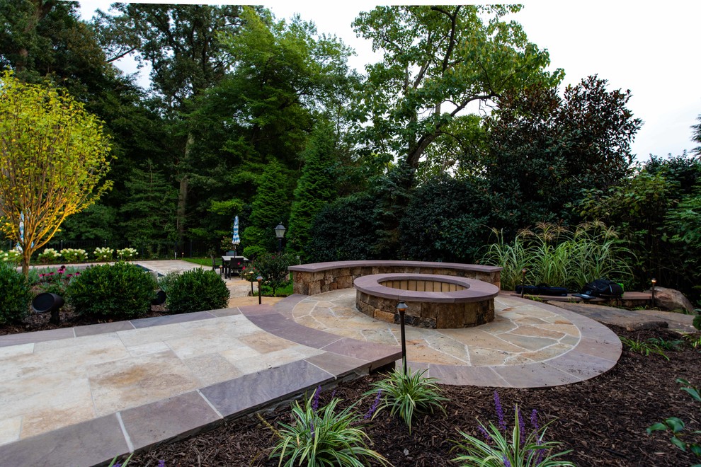 Photo of a modern backyard garden in DC Metro with a fire feature and natural stone pavers.