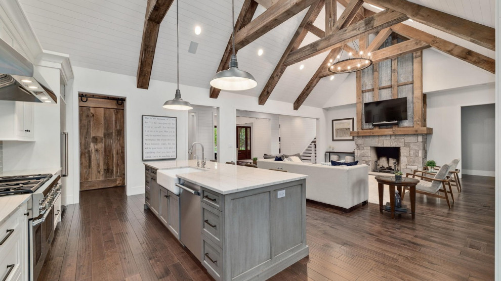 Photo of an expansive farmhouse open plan games room in Chicago with white walls, medium hardwood flooring, a standard fireplace, a stone fireplace surround, a wall mounted tv, brown floors, a vaulted ceiling and tongue and groove walls.