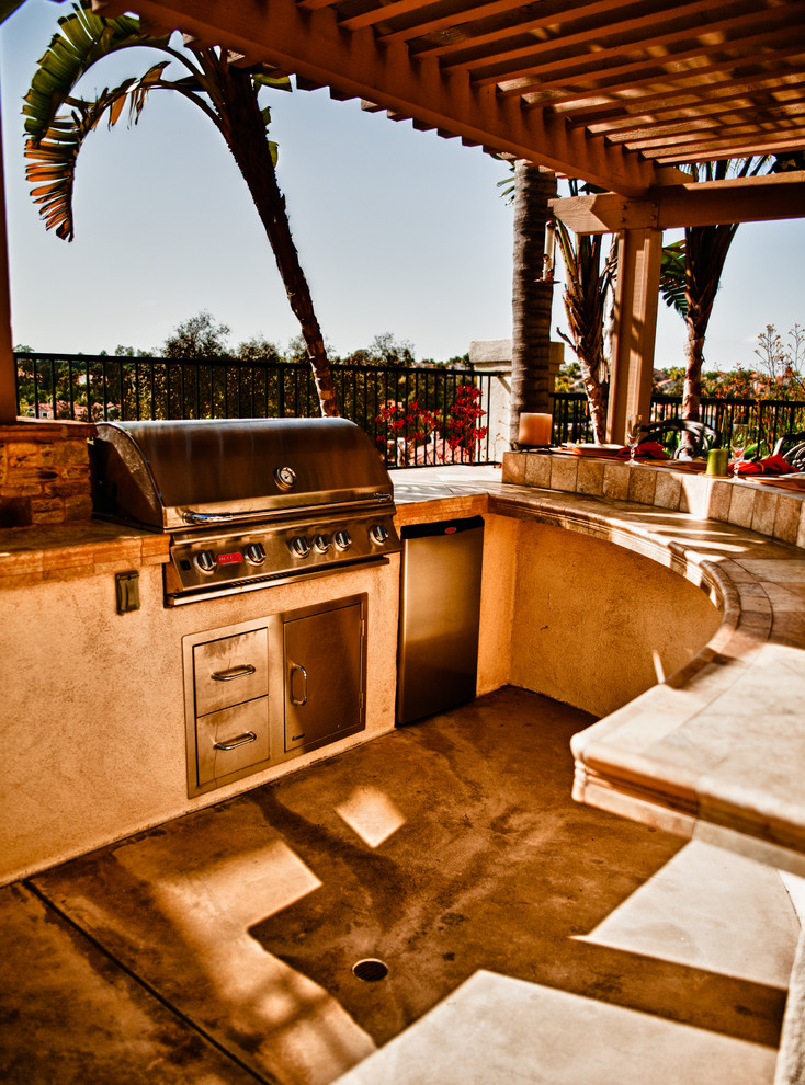 Mid-sized mediterranean backyard patio in Orange County with a pergola and concrete slab.