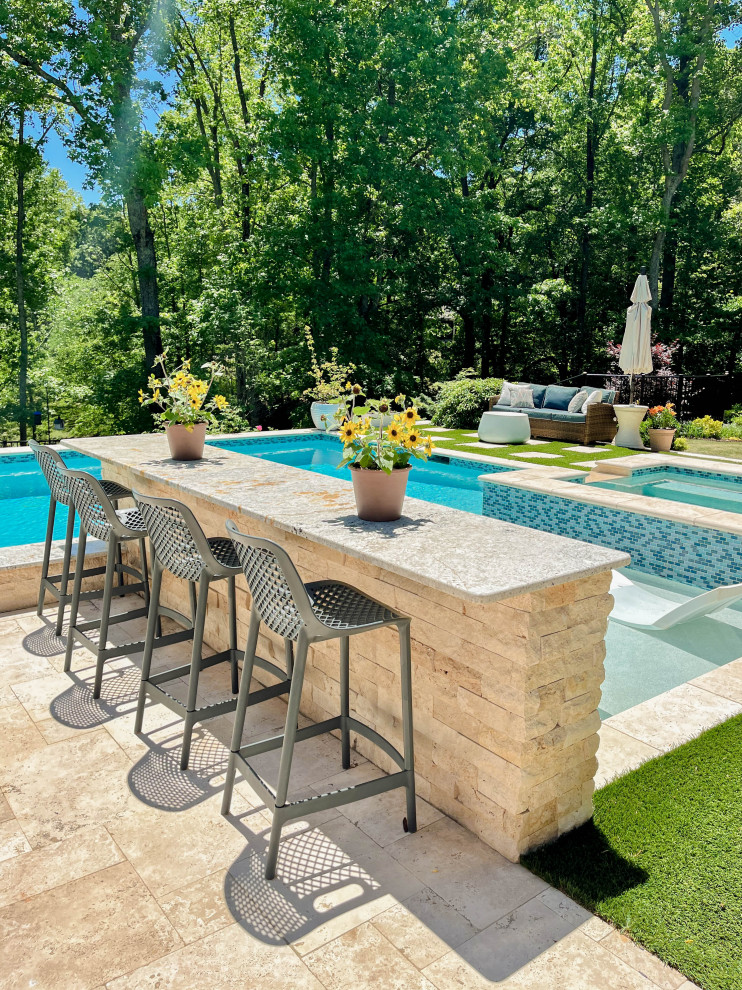 Diseño de piscina tradicional grande a medida en patio trasero con privacidad y adoquines de piedra natural