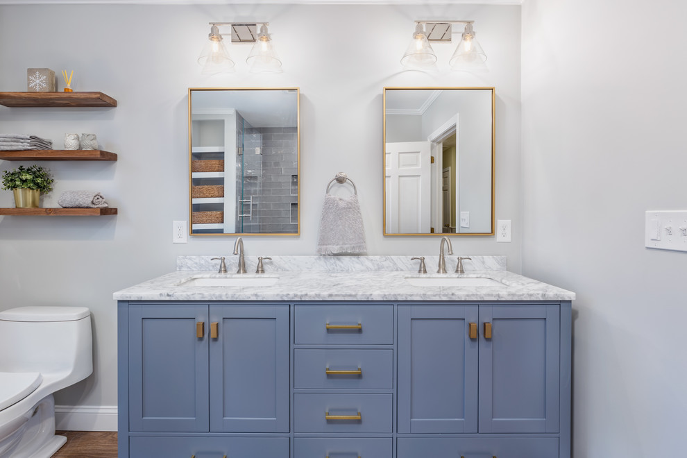 This is an example of a mid-sized transitional kids bathroom in Boston with shaker cabinets, grey cabinets, an alcove tub, an alcove shower, a one-piece toilet, gray tile, glass tile, grey walls, porcelain floors, an undermount sink, engineered quartz benchtops, multi-coloured floor, a hinged shower door and multi-coloured benchtops.