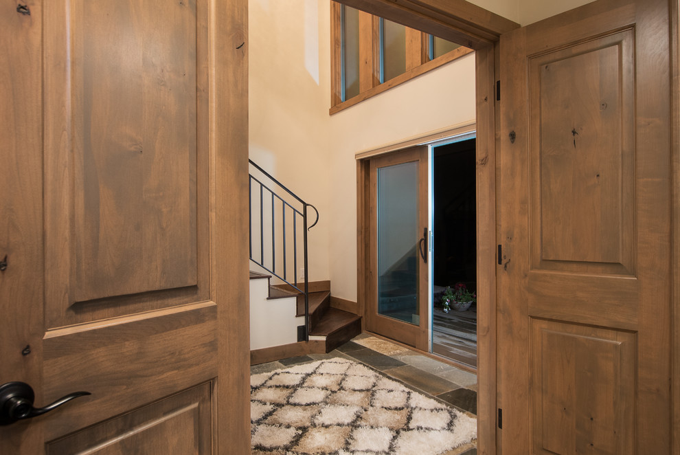 Home design - mid-sized rustic slate floor home design idea with beige walls and a dark wood front door