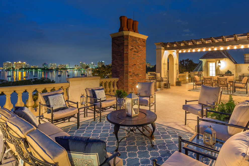 This is an example of a mediterranean rooftop deck in Tampa with a pergola.