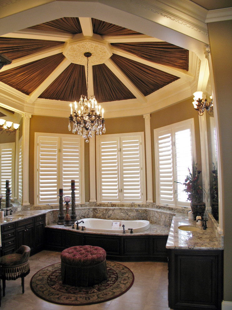 Photo of a large mediterranean master bathroom in New Orleans with dark wood cabinets, marble benchtops and beige walls.