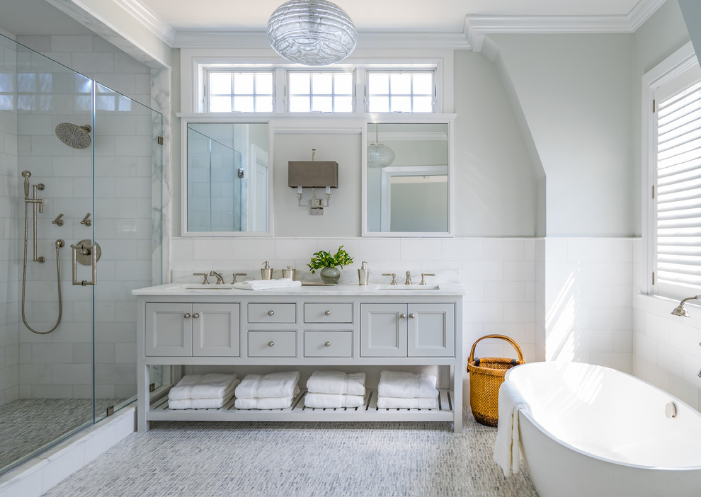 This is an example of a traditional master bathroom in Boston with recessed-panel cabinets, grey cabinets, a freestanding tub, an alcove shower, grey walls, an undermount sink, grey floor and a hinged shower door.