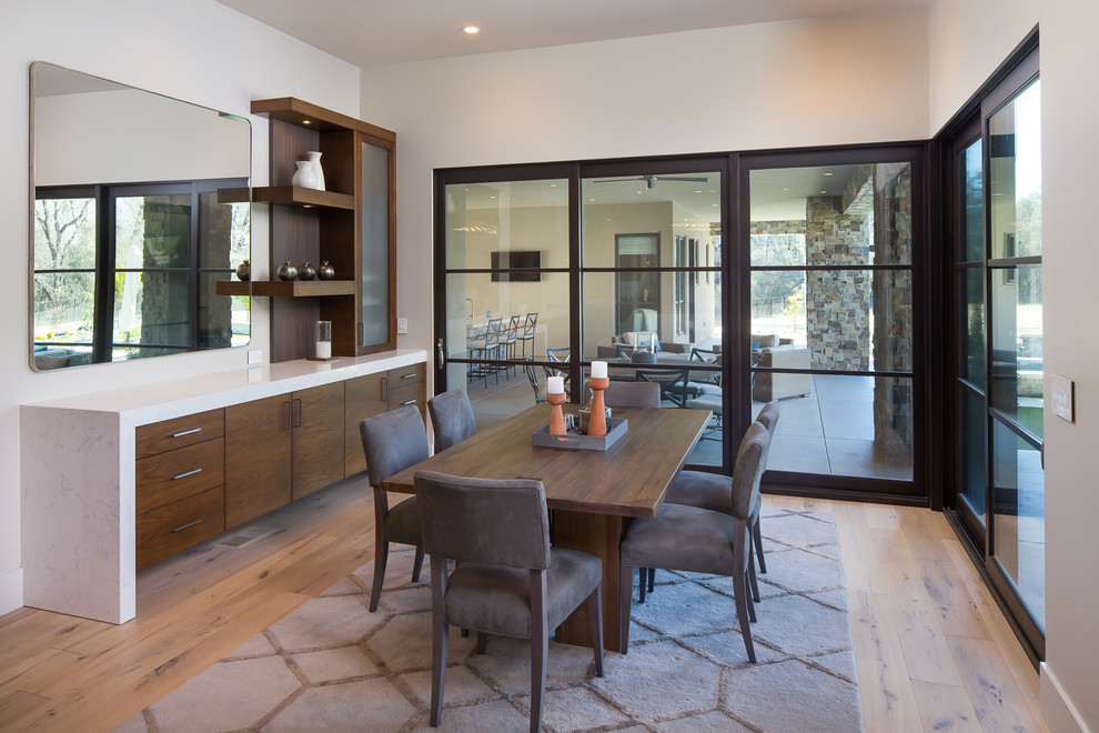 Mid-sized contemporary open plan dining in Sacramento with white walls, light hardwood floors, no fireplace and beige floor.