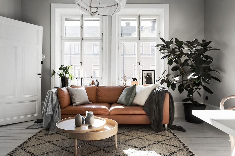 This is an example of a mid-sized scandinavian living room in Stockholm with grey walls, painted wood floors and white floor.