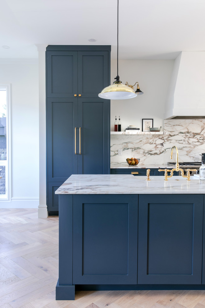 Inspiration for a mid-sized transitional galley light wood floor open concept kitchen remodel in Calgary with a double-bowl sink, shaker cabinets, blue cabinets, marble countertops, multicolored backsplash, marble backsplash, paneled appliances, an island and multicolored countertops