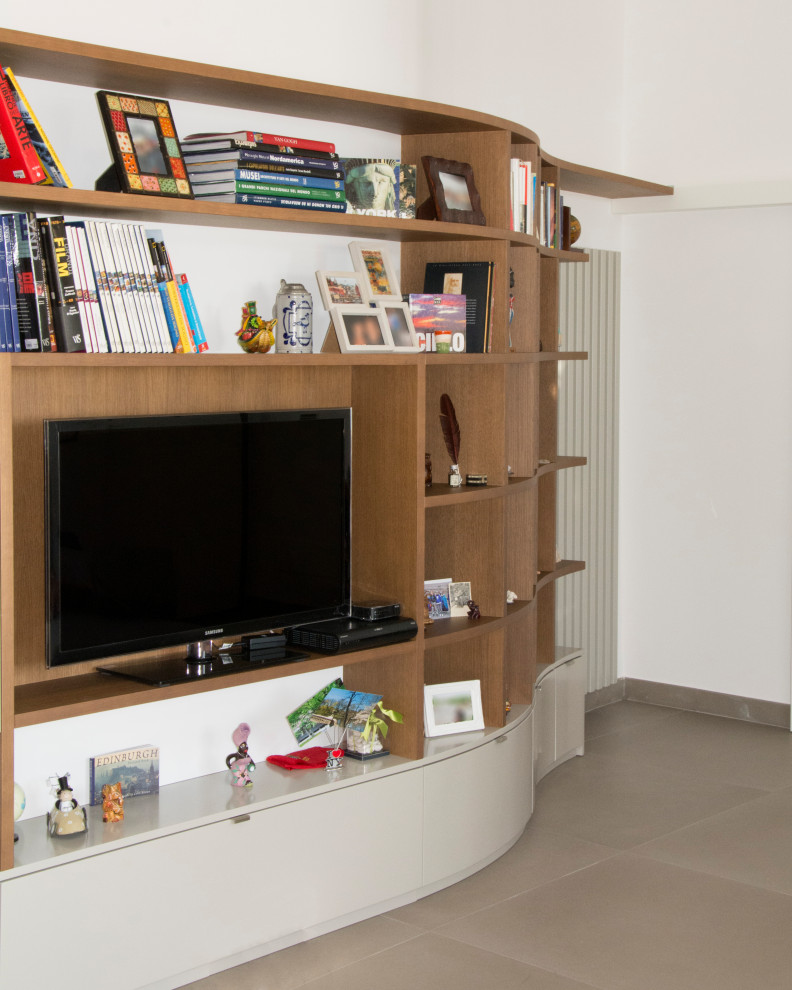 Стильный дизайн: маленькая открытая гостиная комната в стиле модернизм с с книжными шкафами и полками, серыми стенами, полом из керамогранита и отдельно стоящим телевизором для на участке и в саду - последний тренд