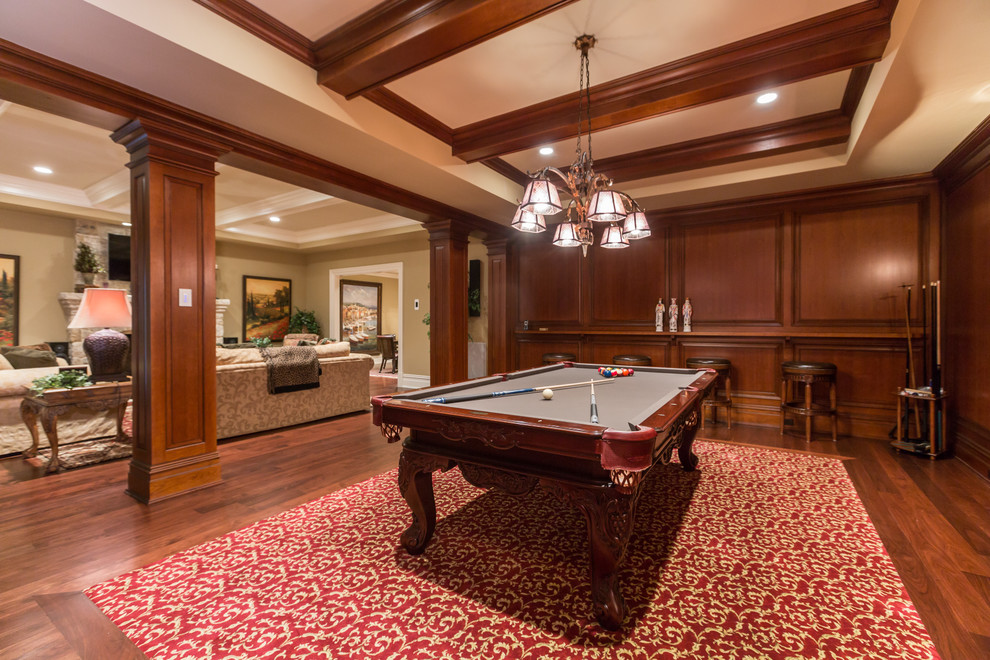 Photo of an expansive traditional enclosed family room in DC Metro with a game room, beige walls, medium hardwood floors, a standard fireplace, a stone fireplace surround and a built-in media wall.