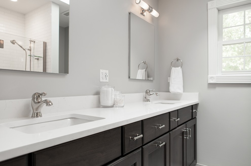 Design ideas for a mid-sized transitional kids bathroom in Chicago with flat-panel cabinets, white cabinets, a shower/bathtub combo, a two-piece toilet, gray tile, marble, grey walls, porcelain floors, a drop-in sink, quartzite benchtops, grey floor and a sliding shower screen.