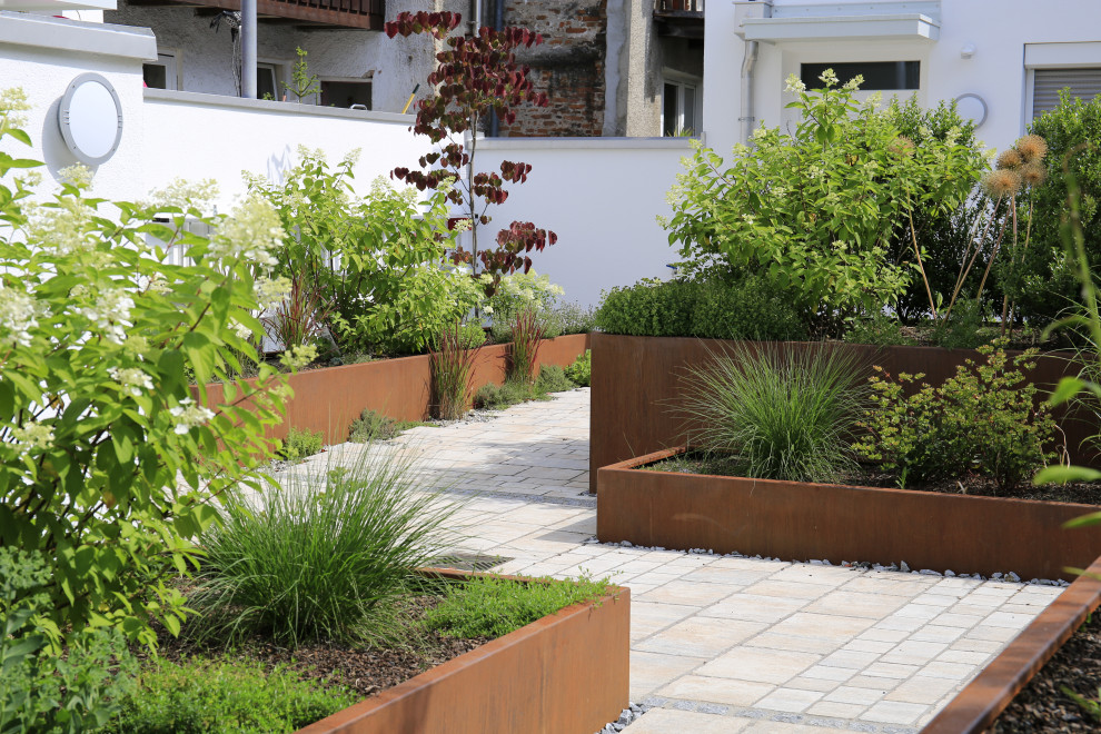 Inspiration for a large contemporary rooftop full sun garden in Munich with with flowerbed and natural stone pavers.