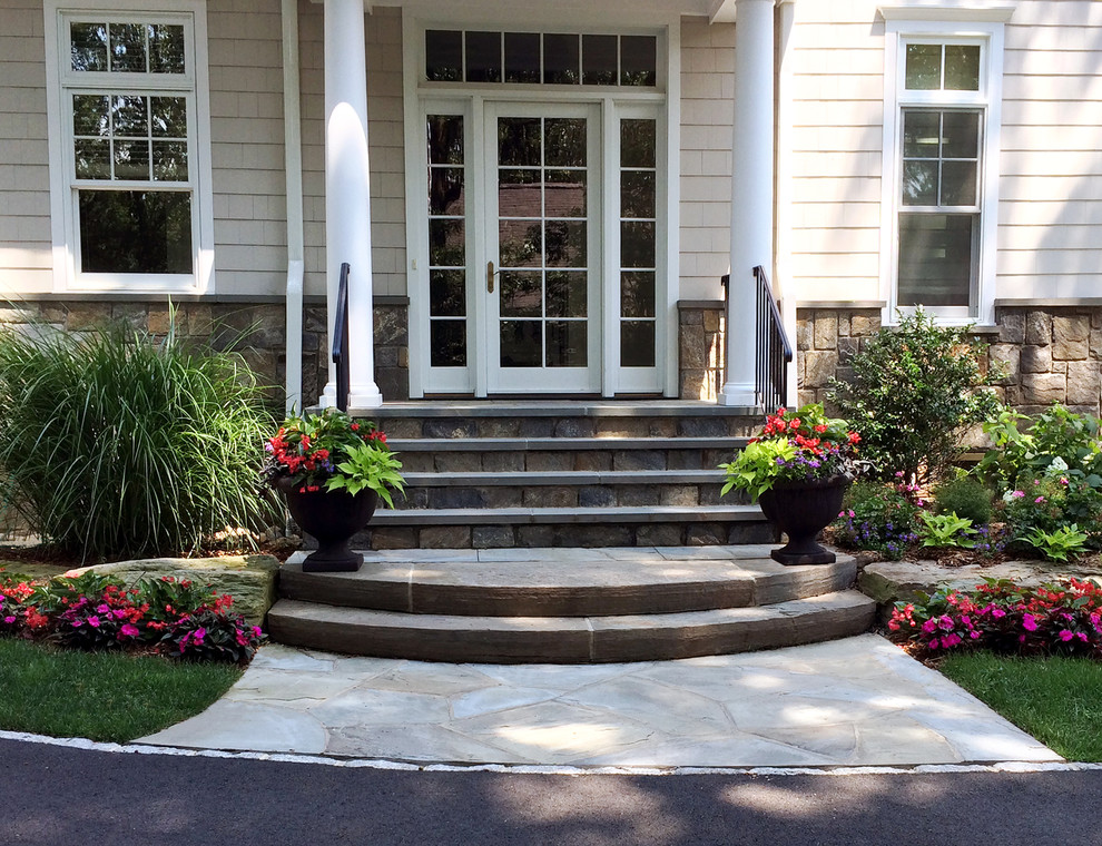 Design ideas for a traditional side yard verandah in New York with a container garden and natural stone pavers.
